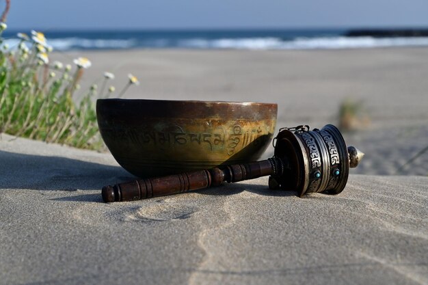 Photo singing bowl on the beach and prayer wheel mantra translation transform your impure body