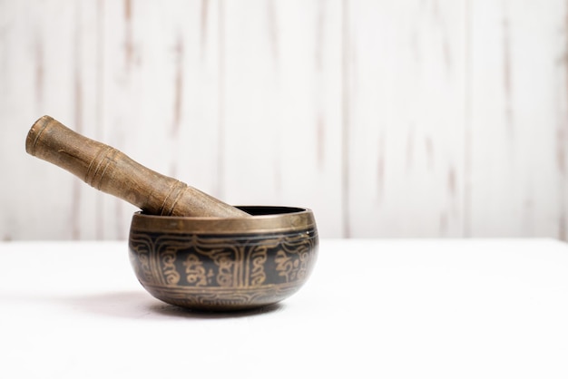 Singing bowl on a light wooden background