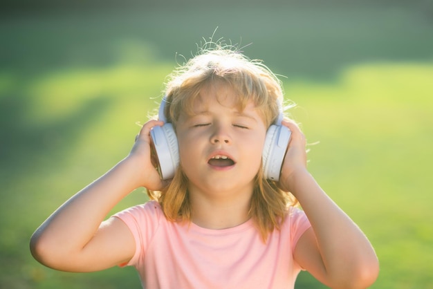 Singing children child with listening to music using headphones amazed with open mouth funny kids fa