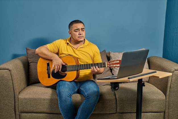 Singing and playing guitar at home on a relaxed couch