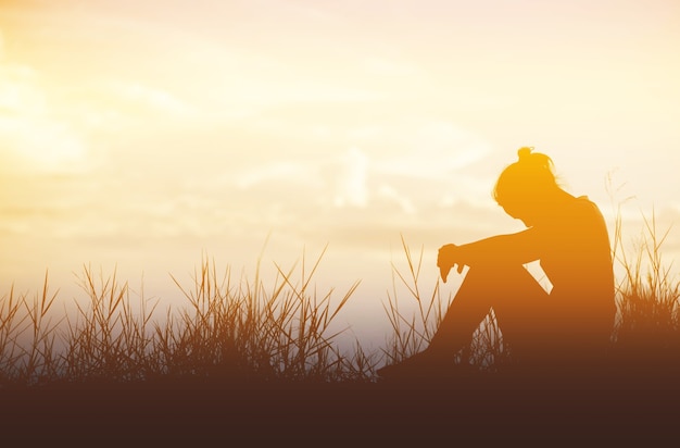 単一の大人の女性のシルエットと夕日