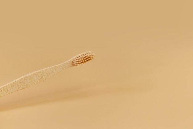 Single Bamboo wooden toothbrushe on beige background