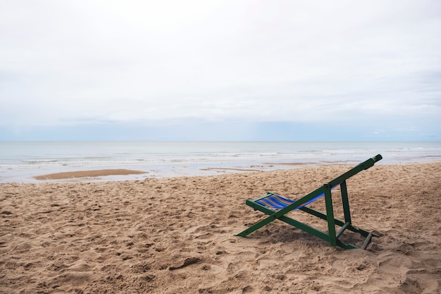 Photo a single beach chair by the sea with blue sky background