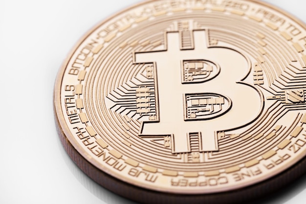 Single bitcoin coin or icon standing in sharp focus on a\
reflective surface with gold colored backgr