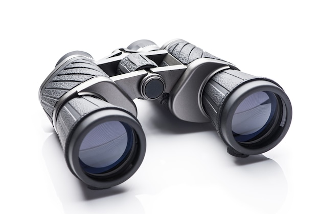 Single black pair of binoculars isolated on a white background.