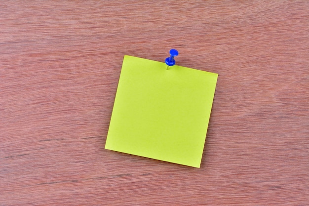 Photo single blank note paper attached to a wooden wall