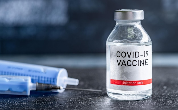 Covid19 ワクチンの 1 本のバイアル 医療コンセプト 予防接種 皮下注射治療 ワクチンとシリンジ注射