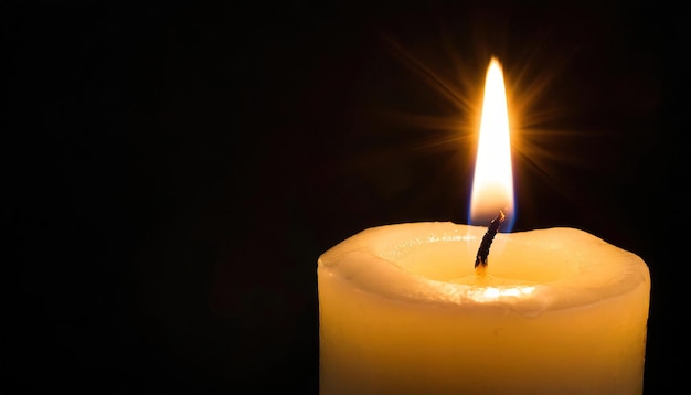 Single burning candle isolated on black background