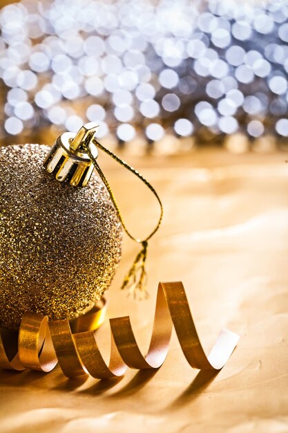 Single christmas ball and gold colored ribbon