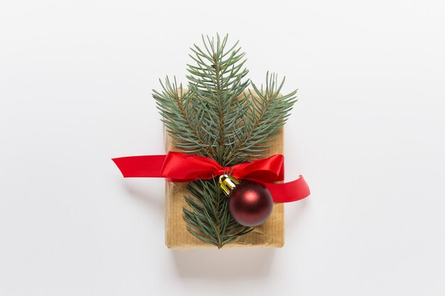 Single Christmas present with fir branch and red bow