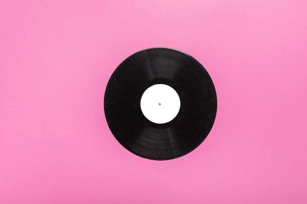 Single circular vinyl record on pink background