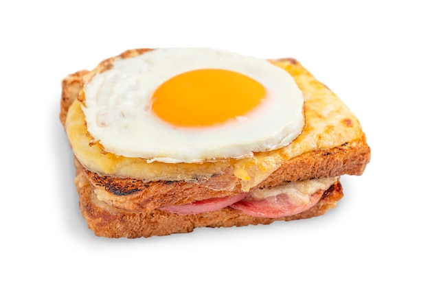 Один французский сэндвич croque madame с сыром, ветчиной и жареным яйцом сверху, изолированный на белом