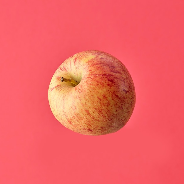 Single fresh raw apple isolated on pink background