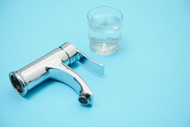 Single handle water tap on light blue background, closeup