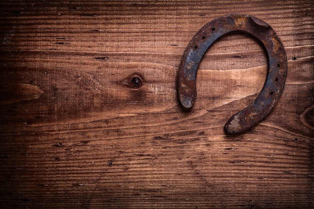 Photo single horseshoe on vintage wooden board