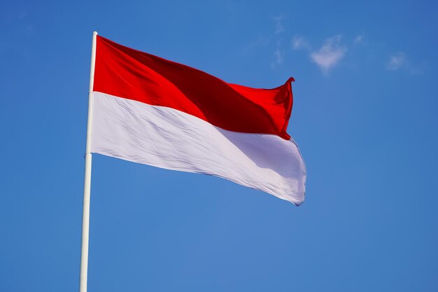 The single large red and white indonesian flag flutters in the strong wind ahead independence day