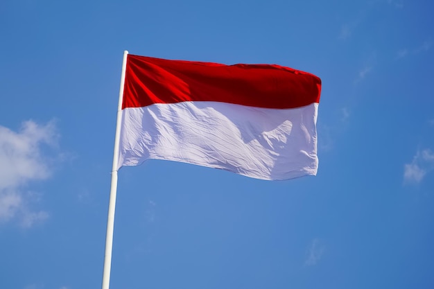 インドネシアの赤と白の大きな旗が独立記念日の前に強い風でらぎます