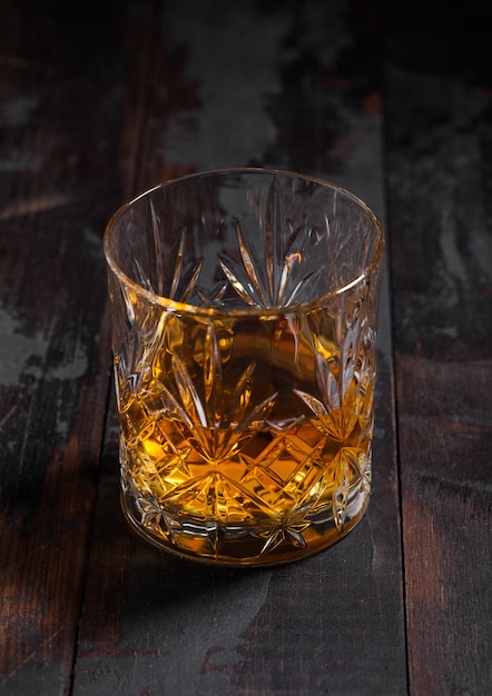 Single malt scotch whiskey in crystal glass on wooden table