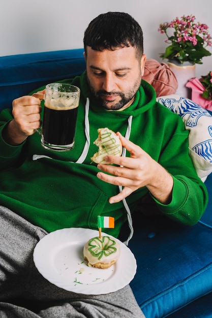 A single man having donuts and stout for breakfast to celebrate St Patricks Day