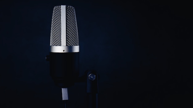 Single microphone on dark blue wall background