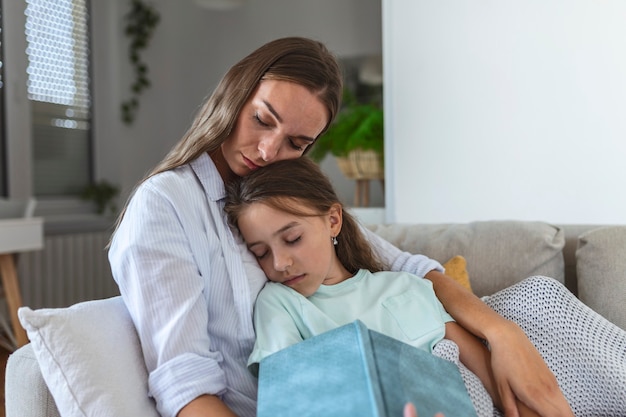 Single mother feel asleep while reading a book to her daughter.