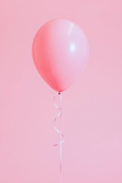 Single pastel pink balloon with a string