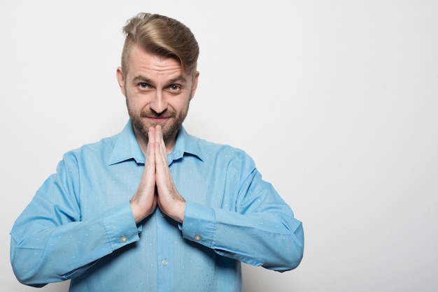 Single pensive bearded man in blue shirt and calm expression