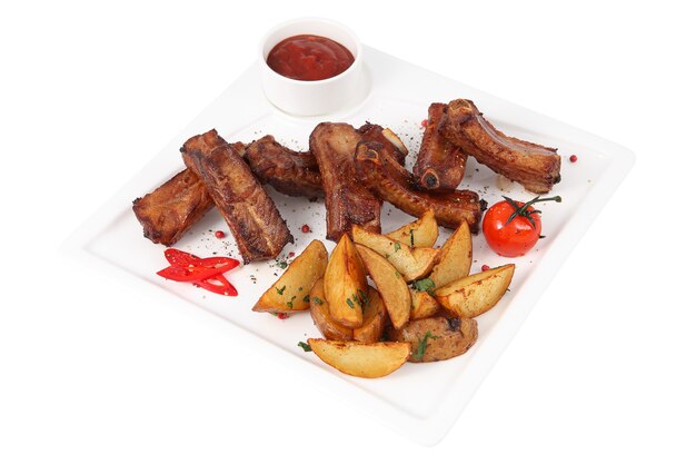 Single pork ribs with potato wedges on white square serving platter, isolated on white background.