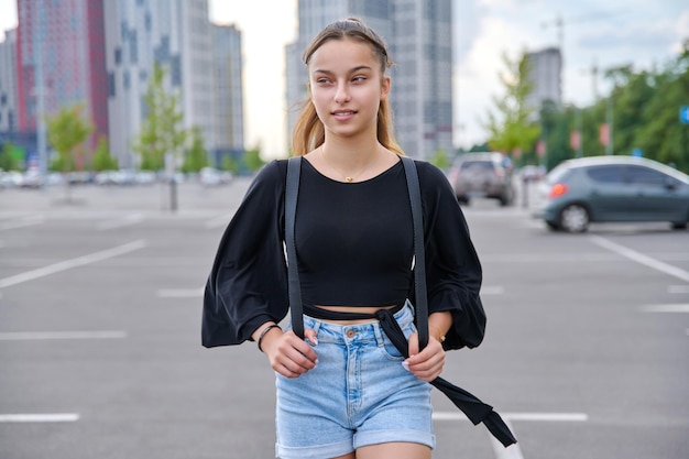 Single portrait of beautiful smiling teenage girl looking to the side