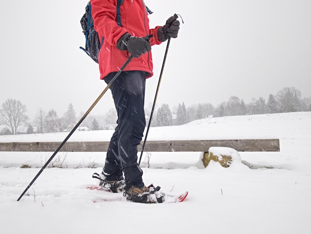 Foto una sola camminatrice di neve o sciatrice sportiva e nuvole grigie sullo sfondo della neve in polvere che cade