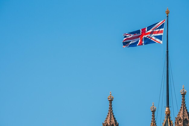 Фото Единственный флаг юнион-джек, размахивающийся перед биг-бэном в здании парламента в лондоне (великобритания)