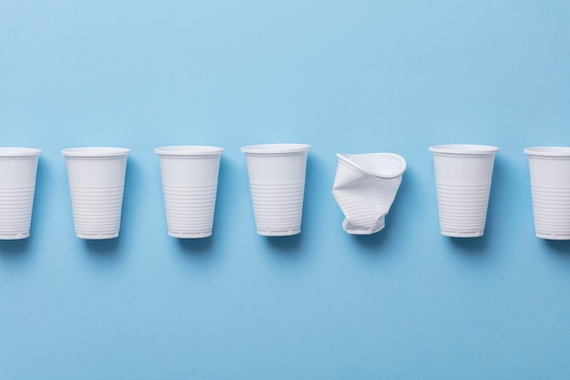 Single use white plastic cups on a blue background