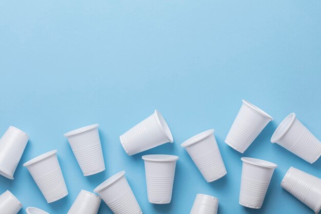 Single use white plastic cups on a blue background