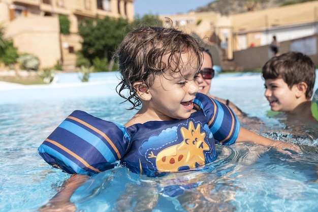 Singleparent family playing in the swimming pool Summer arrives in the northern hemisphere