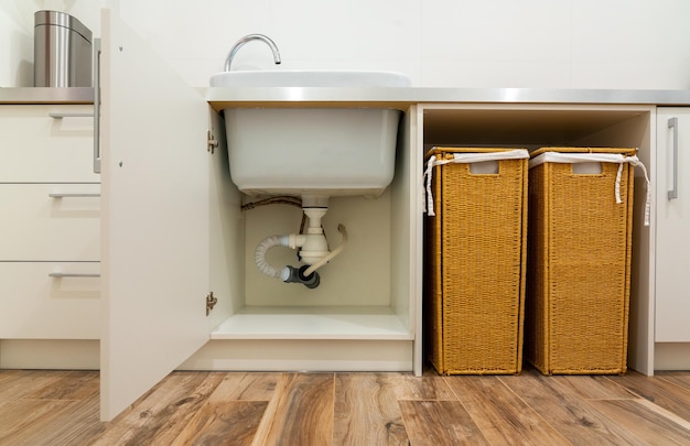 Photo sink and laundry baskets in modern laundry room
