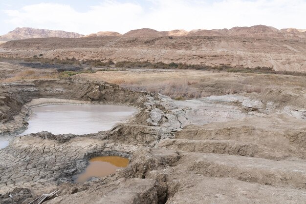 Sinkhole filled with turquoise water near dead sea coastline hole formed when underground salt is