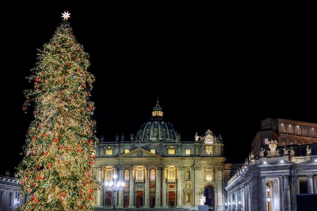Sint-Pietersbasiliek versierd met kerstverlichting en boom Nachtscene kerstboom