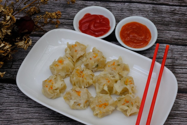 siomay op een witte keramische plaat. tomatensaus. chilisaus. dim som. shumai Japans, Chinees eten.