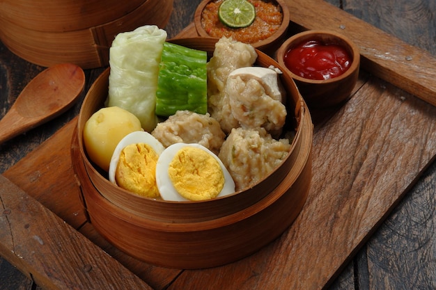 сиомай или сомай, индонезийские рыбные клецки на пару с овощами, подаваемые в арахисовом соусе.