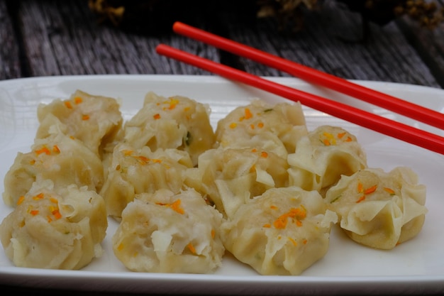 siomay on a white ceramic plate. tomato sauce. chili sauce. dim sum. shumai Japanese, Chinese food.