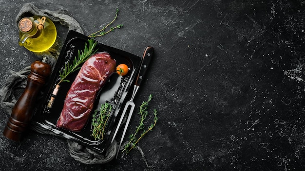 Sirloin beef steak in vacuum packaging market top view flat lay\
top view on black stone cutting table