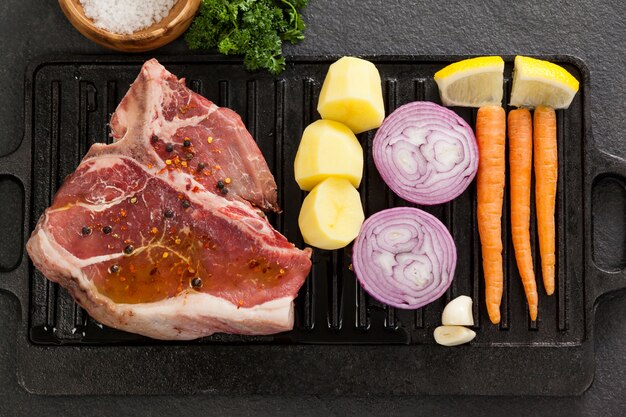 Sirloin chop and ingredients on black grill