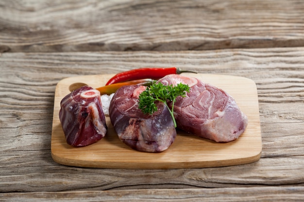 Sirloin chop, salt and chili on wooden board