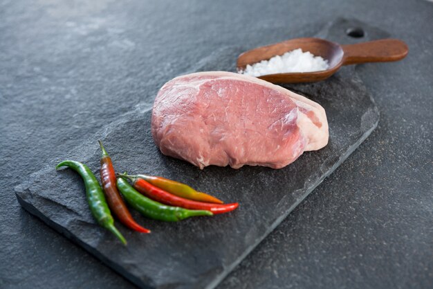 Sirloin chop, salt and chillies on slate plate