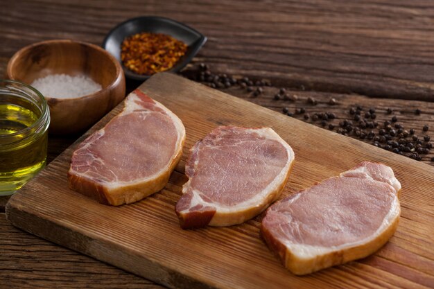 Sirloin chops on wooden board with ingredients