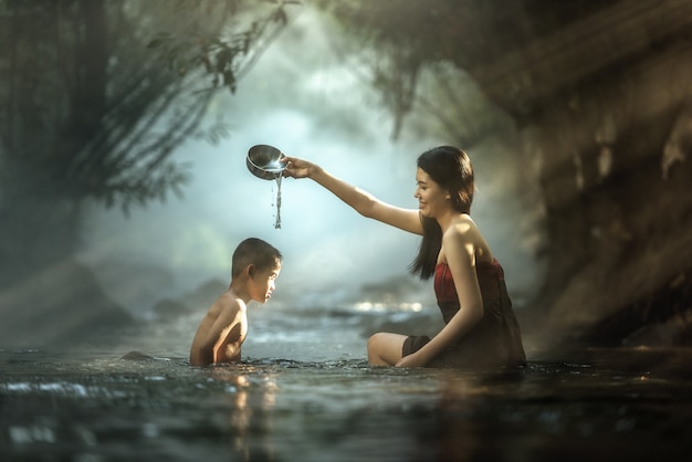 Sister and brother bathing in cascade, Thailand