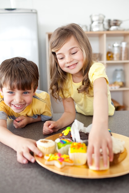 Sister and brother eating cookies