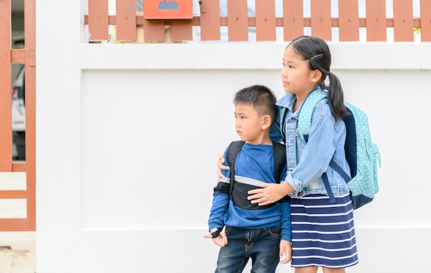 Sister and brother looking school bus 