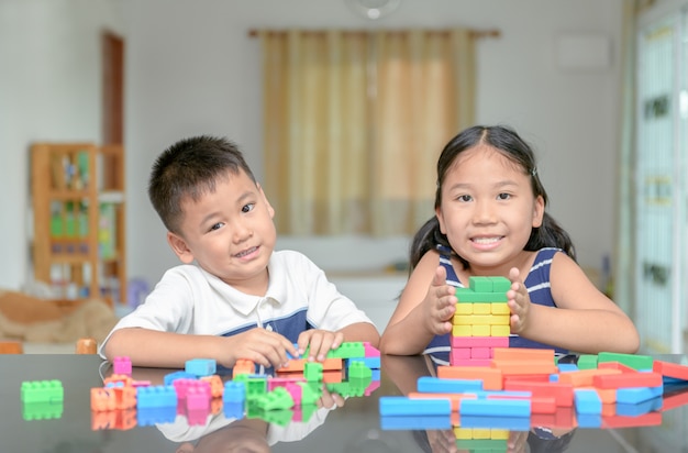 Sister and brother play wood brick tower, 