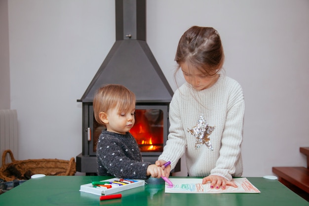 Sister teaching her brother how to paint